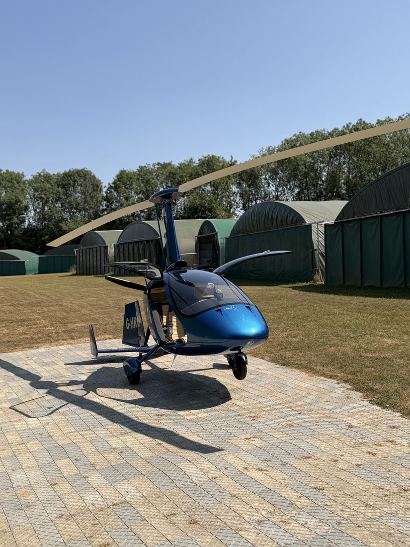 G-HRCP, a blue Magni M24 Plus gyroplane, parked in front of the hangars